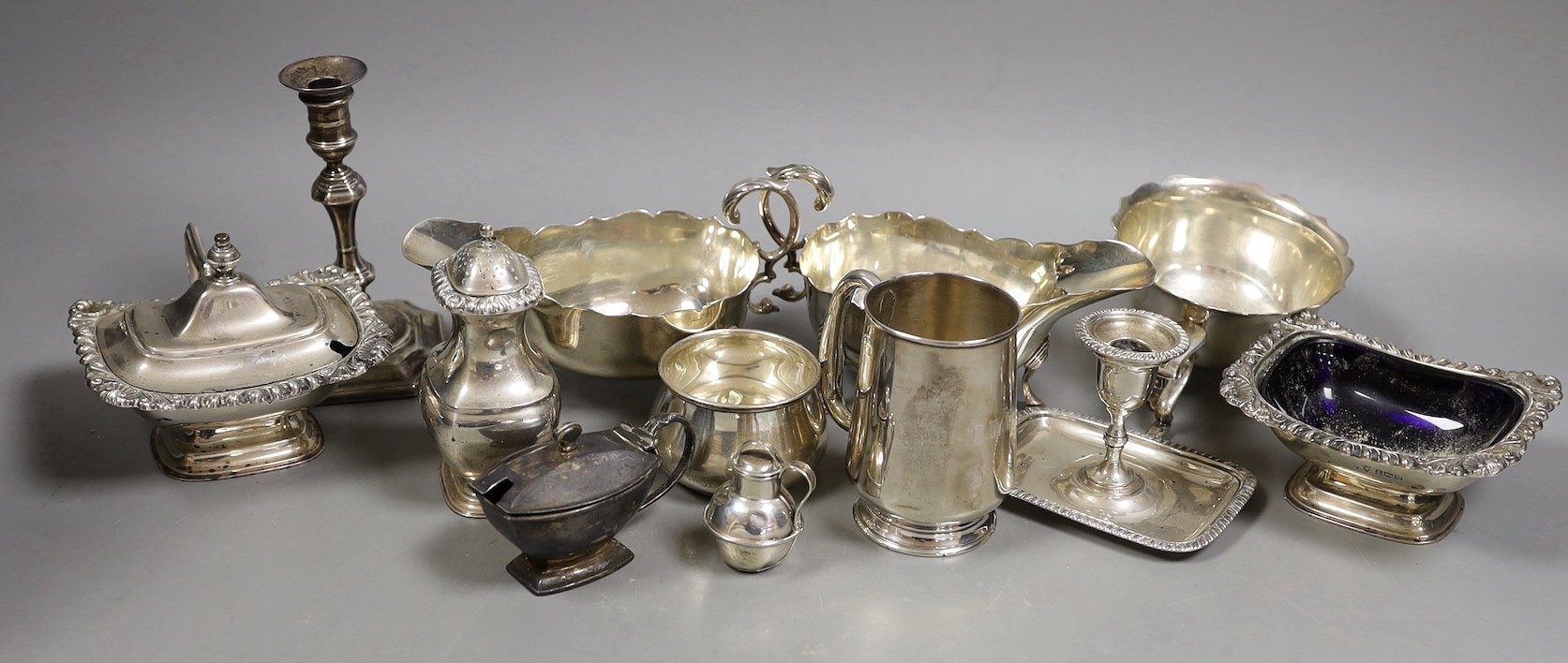 A pair of late Victorian silver sauceboats, Frederick Augustus Burridge, London, 1899, a George V silver mounted taperstick, a modern silver three piece condiment set, a silver chamberstick, silver mug, two silver small